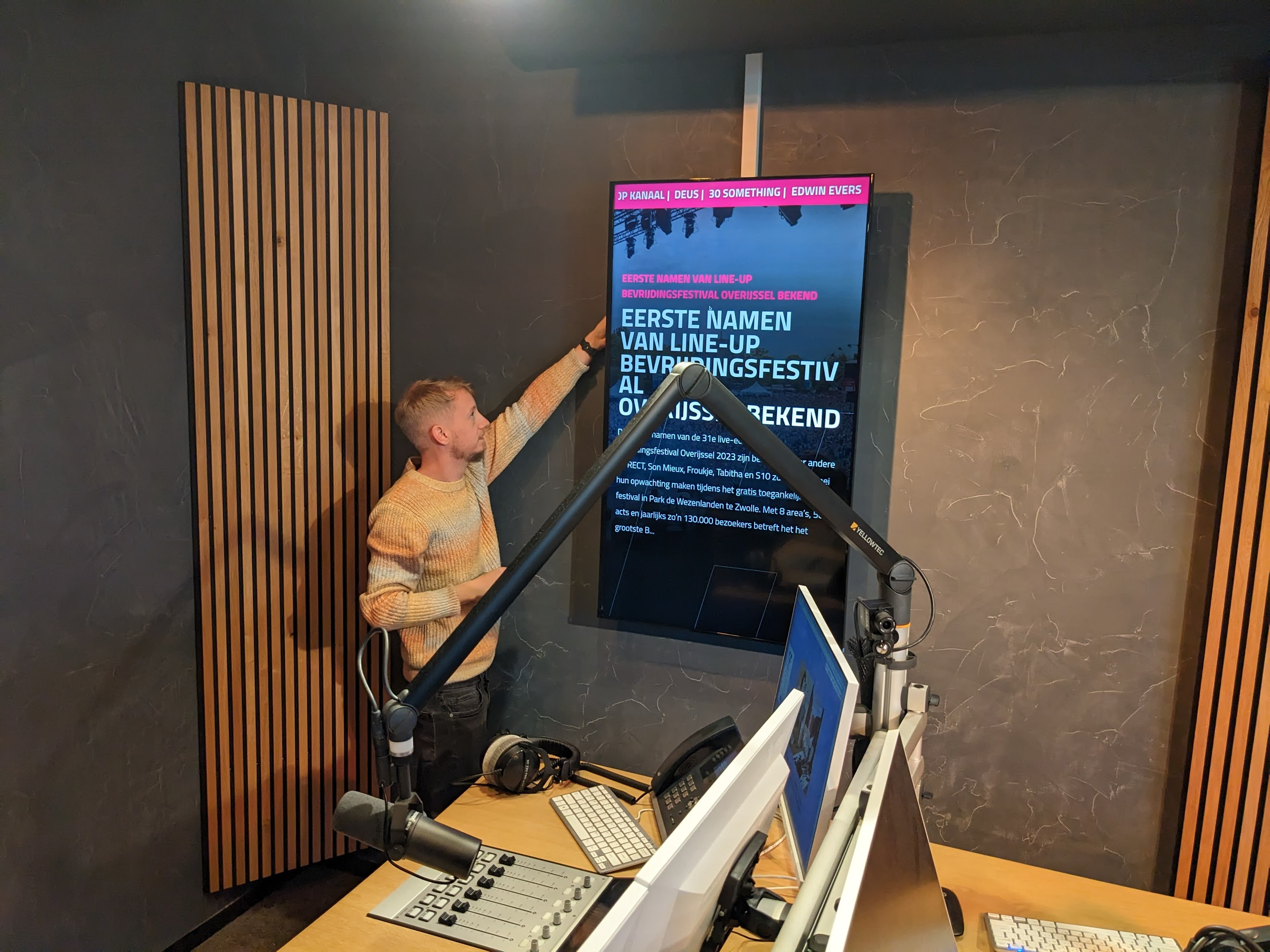 Medewerker van Foster aan het werk bij Hedon om narrowcasting scherm te installeren