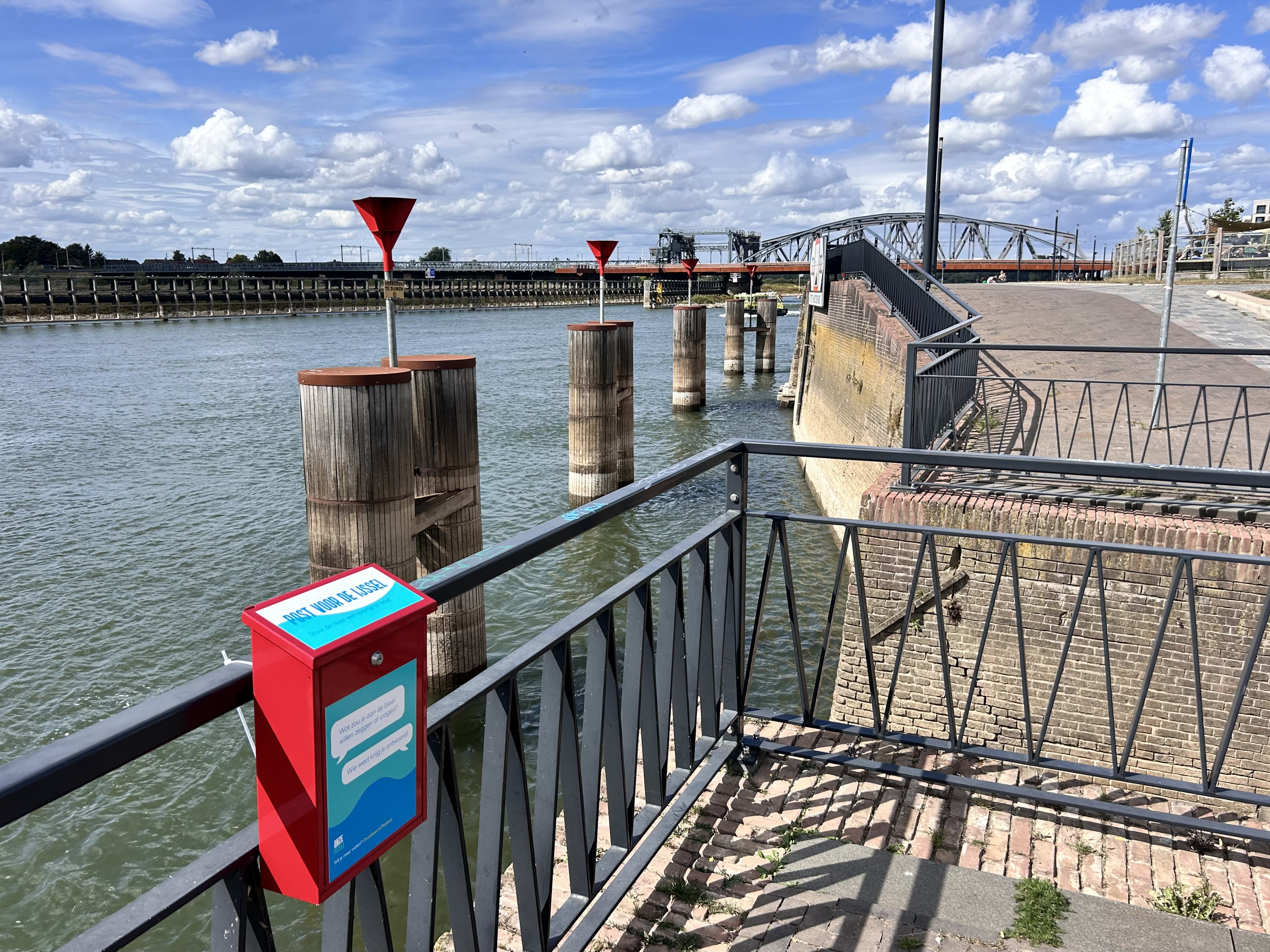 Een foto bij de Ijssel met een Onze IJssel post-ideeënbus. Zo komt de fysieke wereld met de online wereld met elkaar